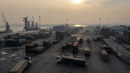 Düşük hareketliliğin görüldüğü İran’daki ticari limanda konteynerler, yük araçları ve vinçler